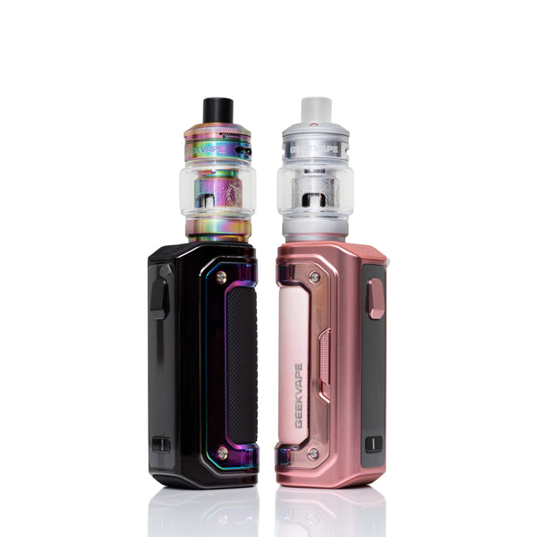 Two Geekvape portable vape devices standing side by side on a white reflective background. The left device is black with an iridescent rainbow-colored tank.