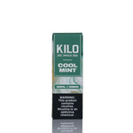 A tall rectangular vape pen box labeled 'KILO COOL MINT' in green and white, with a black nicotine warning panel near the bottom, photographed on a white background with a faint reflection below.