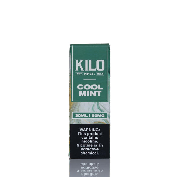 A tall rectangular vape pen box labeled 'KILO COOL MINT' in green and white, with a black nicotine warning panel near the bottom, photographed on a white background with a faint reflection below.